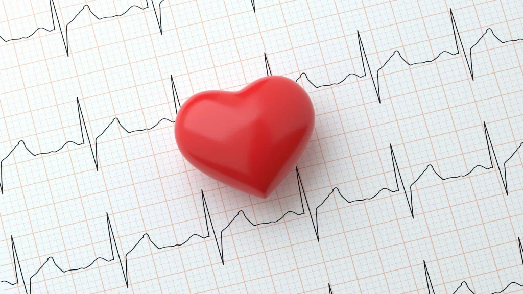 EKG Aufzeichnung auf einem Blatt Papier und davor ein rotes 3D Herz